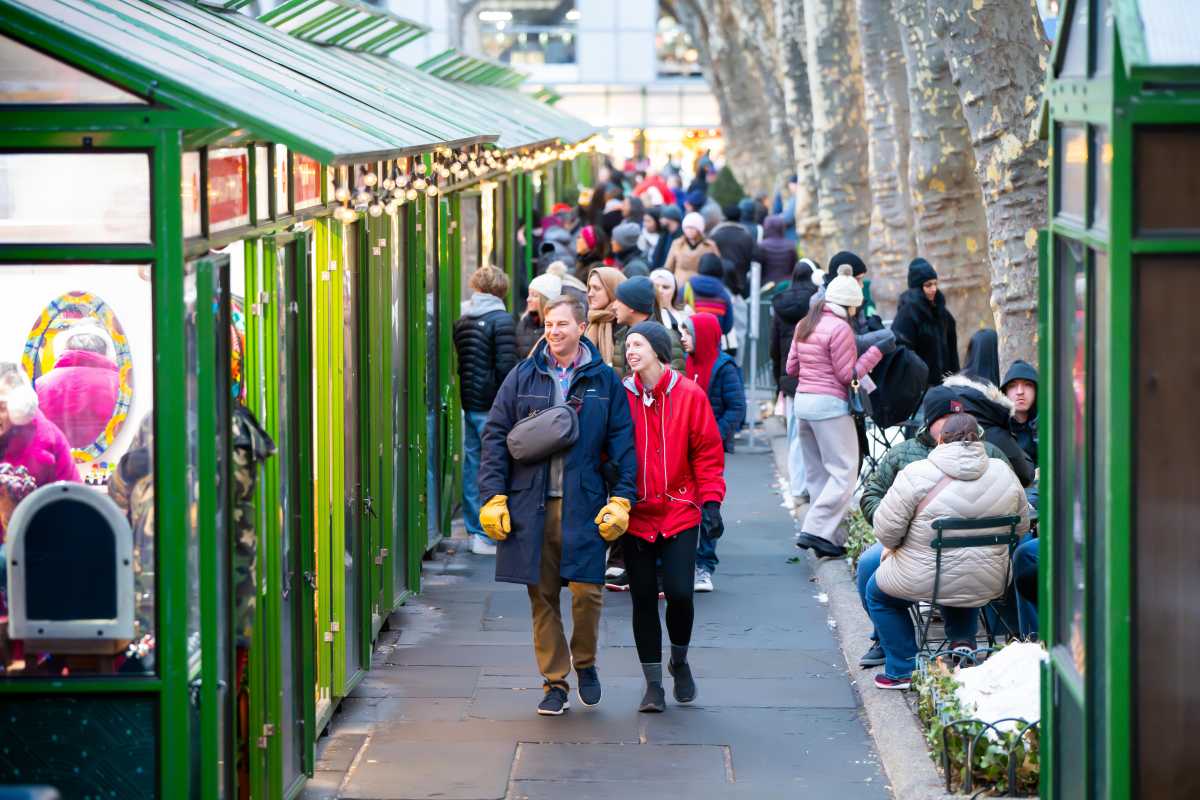 Shoppers stroll and browse the Holiday Shops at Bank of America Winter Village at Bryant Park in New York City.