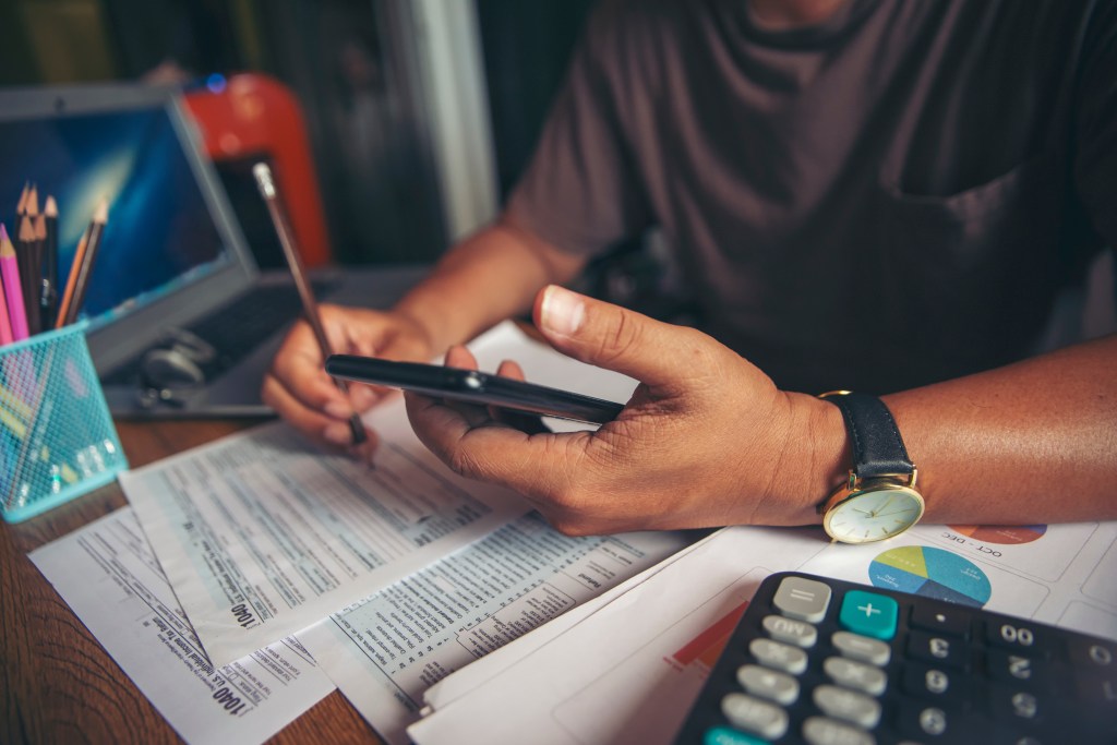 An Asian businessman working at home, planning a budget and calculating a tax return.