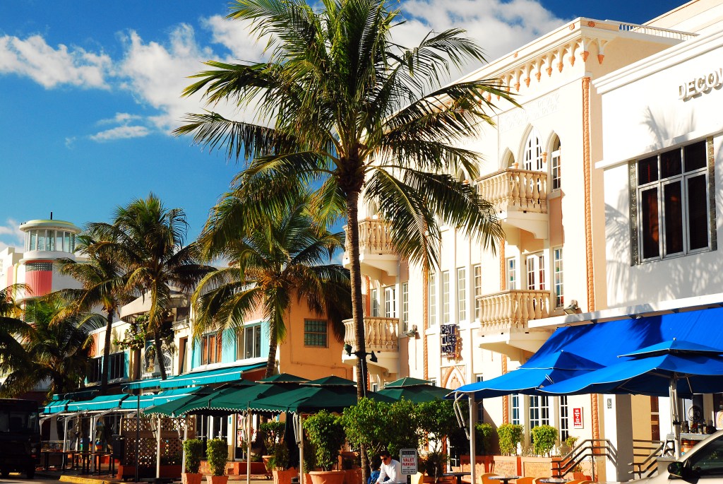 Street-level view of al fresco dining areas with outdoor umbrellas along Ocean Boulevard in South Beach, Miami Beach.