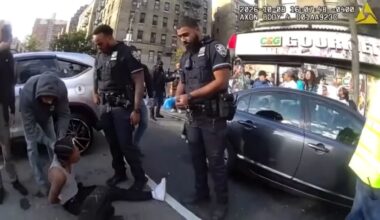 In this image taken from police-worn body camera video released the NYPD, law enforcement personnel tend to a Oscar Belgal, 28, a Dominican man who was shot by Federal immigration officers, Thursday, Oct. 8, 2026, in New York. (NYPD via AP)