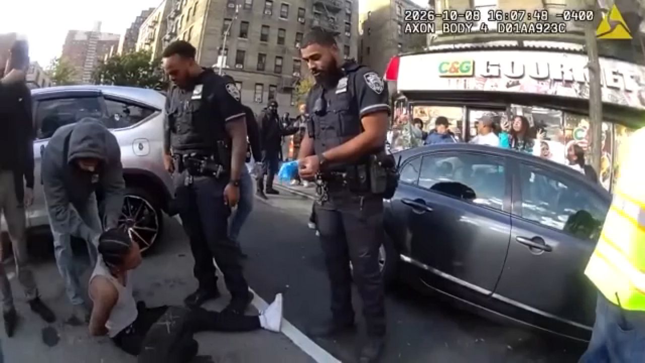 In this image taken from police-worn body camera video released the NYPD, law enforcement personnel tend to a Oscar Belgal, 28, a Dominican man who was shot by Federal immigration officers, Thursday, Oct. 8, 2026, in New York. (NYPD via AP)