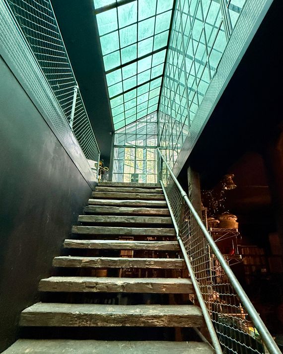 The ground floor, painted black, can be seen to the right. A central stair leads up to the solarium in back. The library glass rises on the right-hand side.