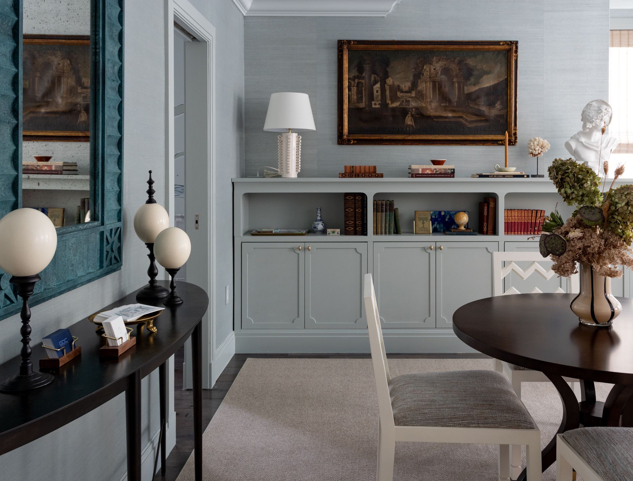 DRAWING ROOM - pale blue walls, table with seating, and storage