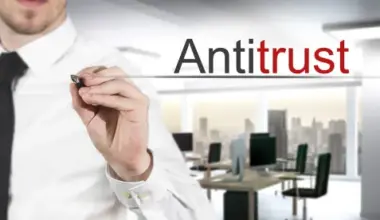 person in button-up and black tie in office underlining "antitrust" in air; Manhattan DA Announces Corporate Crime and Antitrust Task Force