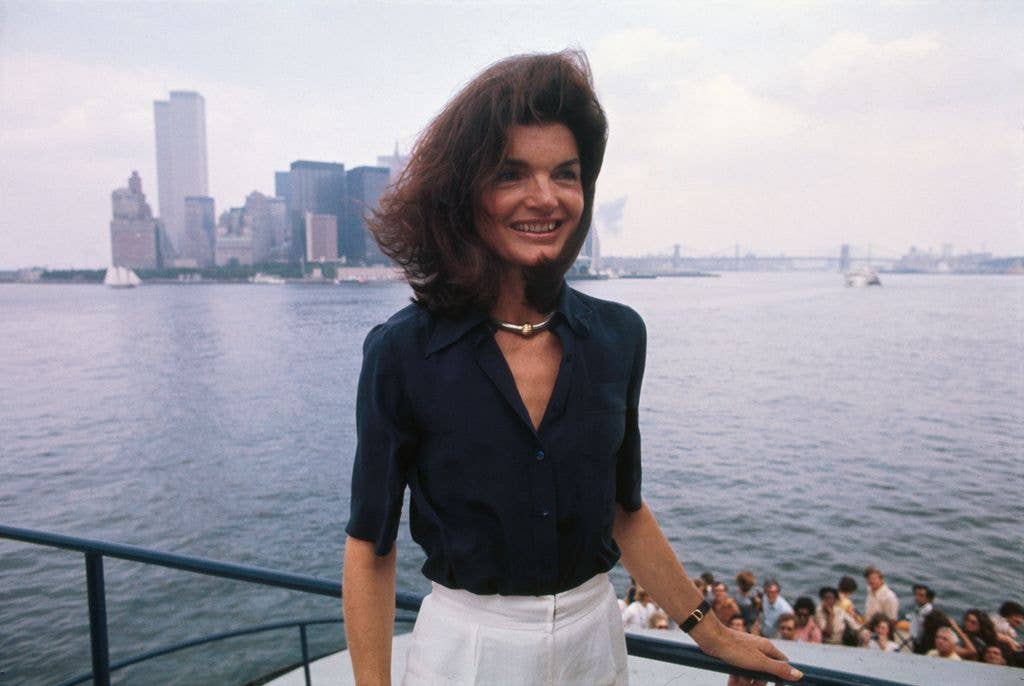 The familiar towers of Manhattan and the not unknown physiognomy of Jacqueline Kennedy Onassis can be made out in the New York Harbor, as she returns to the Big Apple from Staten Island, where she toured the Snug Harbor Cultural Center, 1976