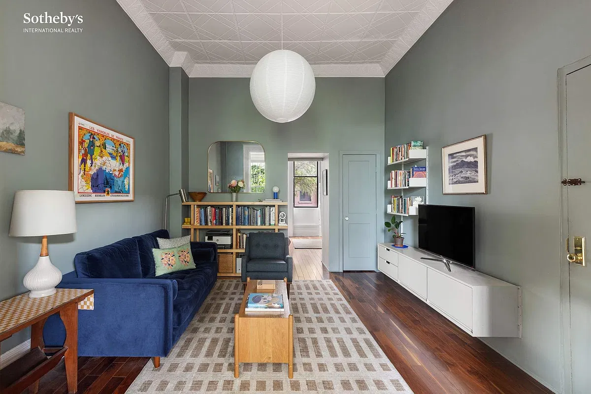 living room with tin ceiling, gray green walls, wood floor