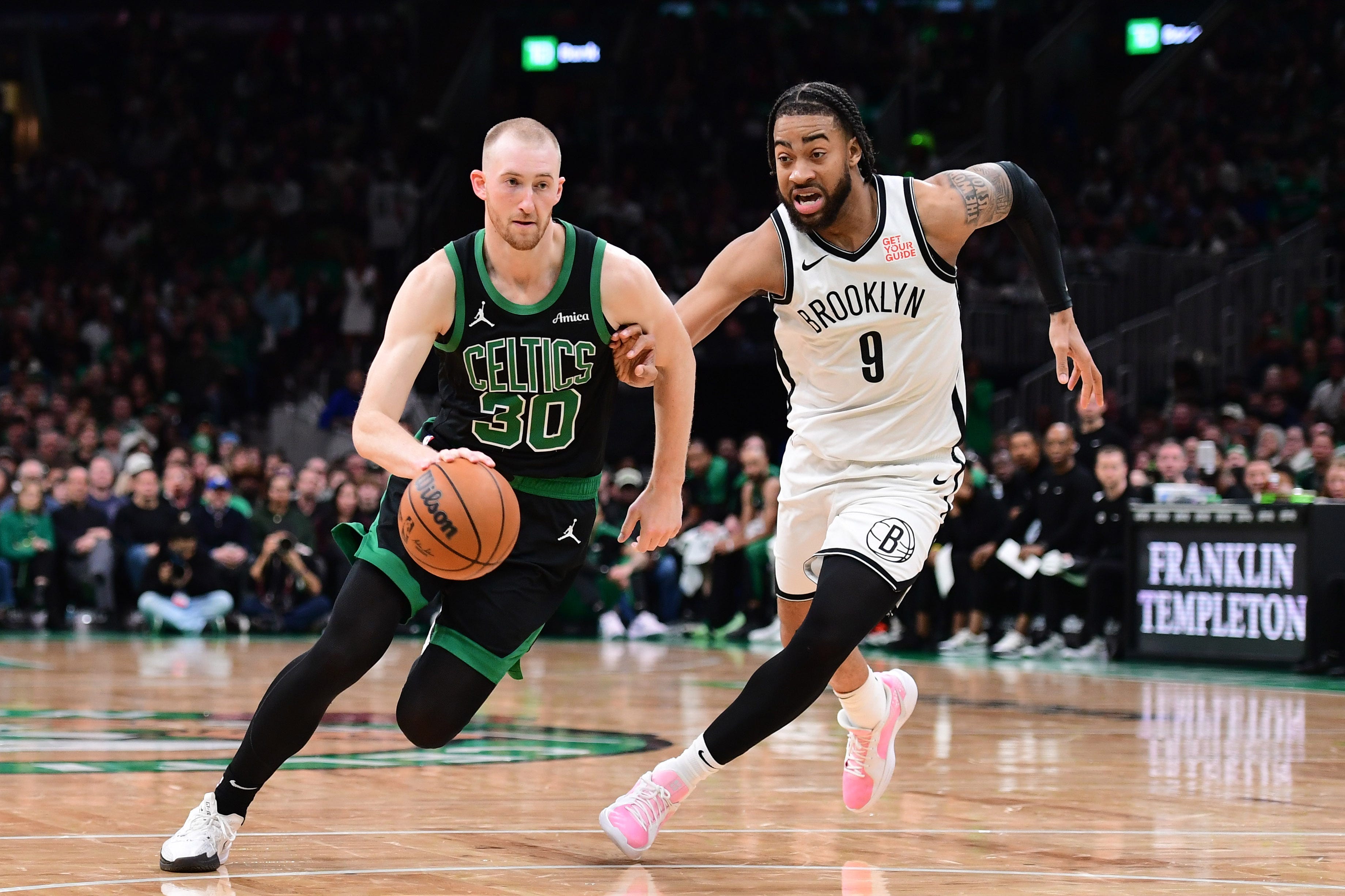 Mar 18, 2025; Boston, Massachusetts, USA; Boston Celtics forward Sam Hauser (30) controls the ball while Brooklyn Nets forward Trendon Watford (9) defends during the second half at TD Garden. Mandatory Credit: Bob DeChiara-Imagn Images