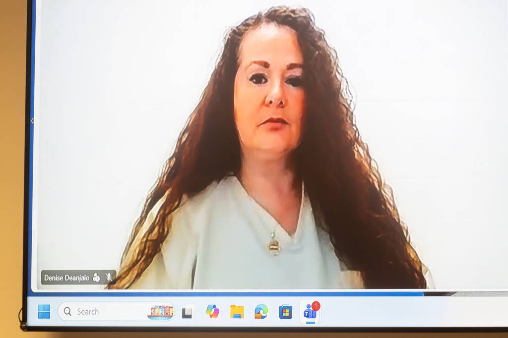 Christa Gail Pike appears remotely on a video call screen from prison.