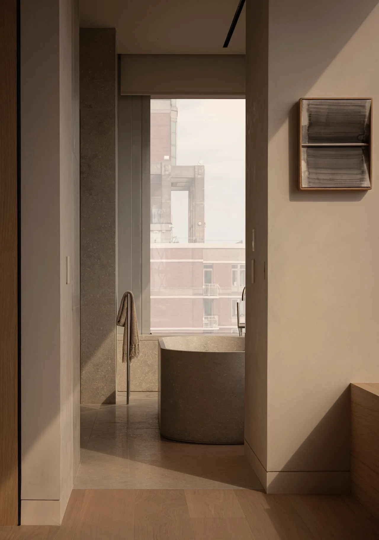 Living room with large windows and minimalistic furniture in a high-rise building.