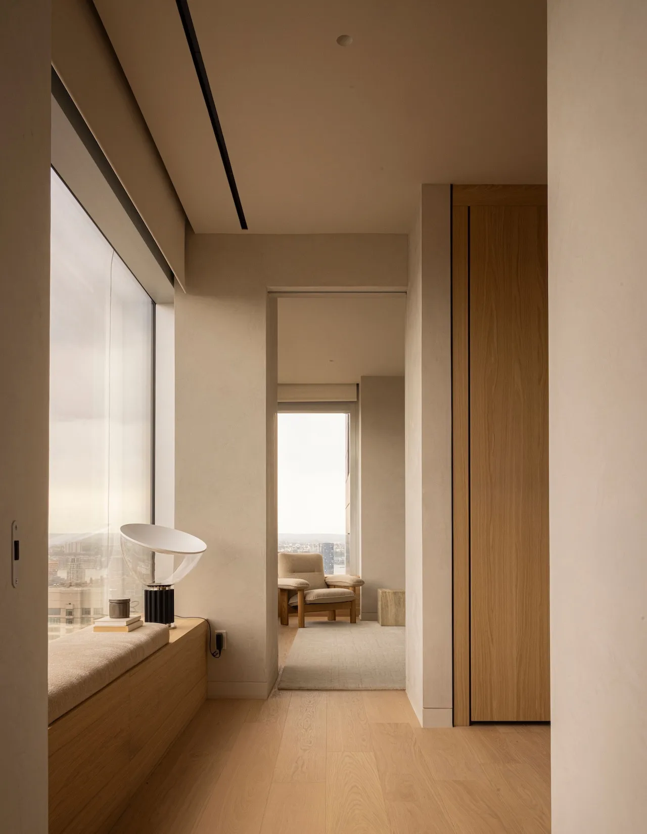 Home office with a sleek desk, bookshelf, and panoramic city views.