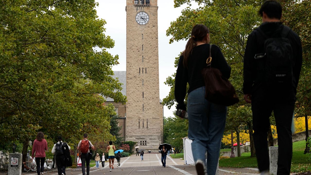 Pedestrians walk on the campus at Cornell University in Ithaca, N.Y., Thursday, Oct. 1, 2026. (AP Photo/Matt Rourke)