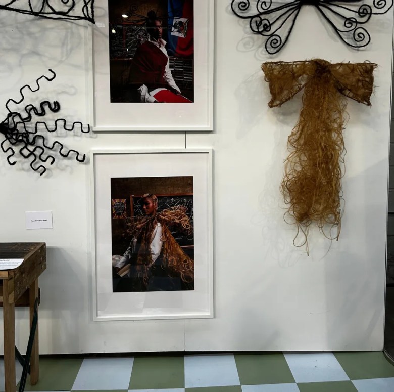 Photographs and intricate hair sculptures featured in Haitian-American artist Kayra Theodore’s “The Art & Rituals of Hair” exhibition at CultureCon 2026 at the Brooklyn Navy Yard. Photo by Catherine Roth / The Haitian Times
