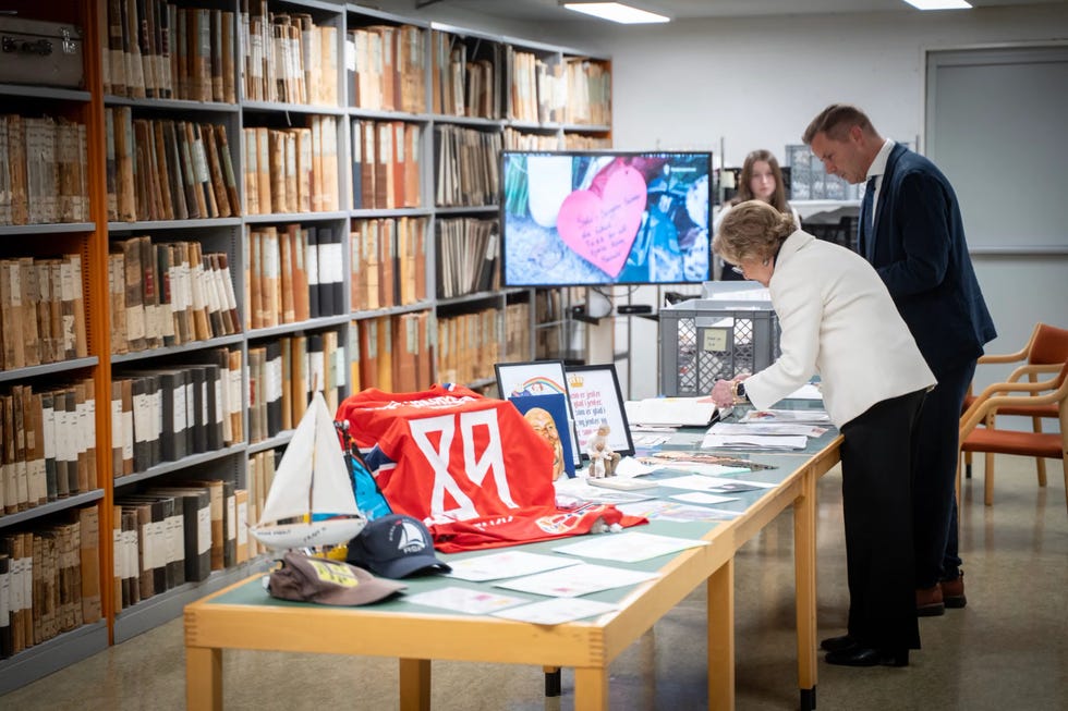 Visitors exploring a display of artifacts and documents in a library or archive setting.