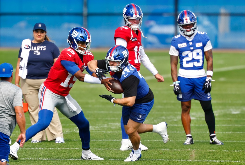 New York Giants quarterback Jameis Winston (19) hands off the ball to running back Cam Skattebo during football practice.
