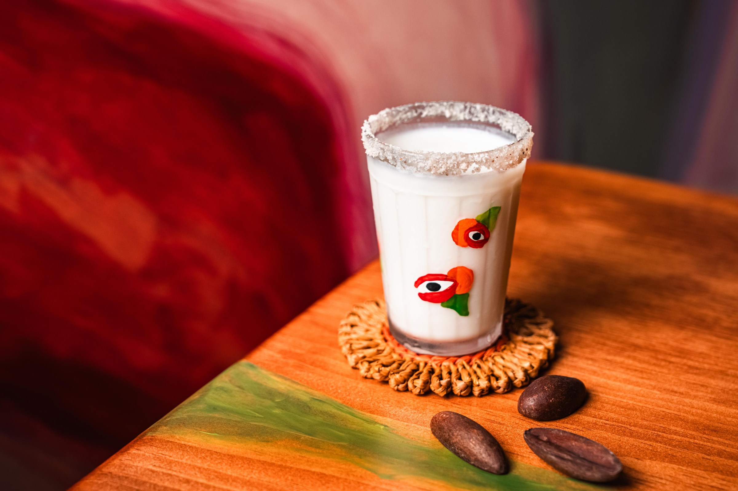 A glass with red eyes on it with a white cream in it.