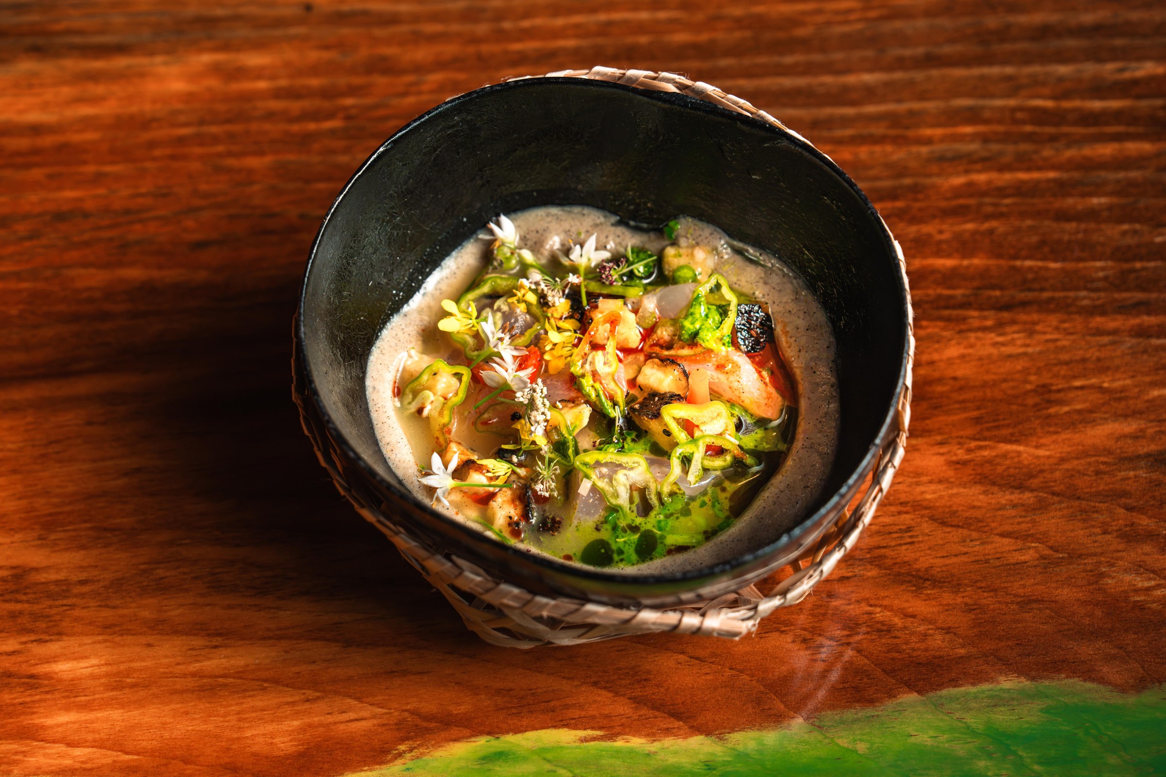 A bowl of white broth with sliced fish.