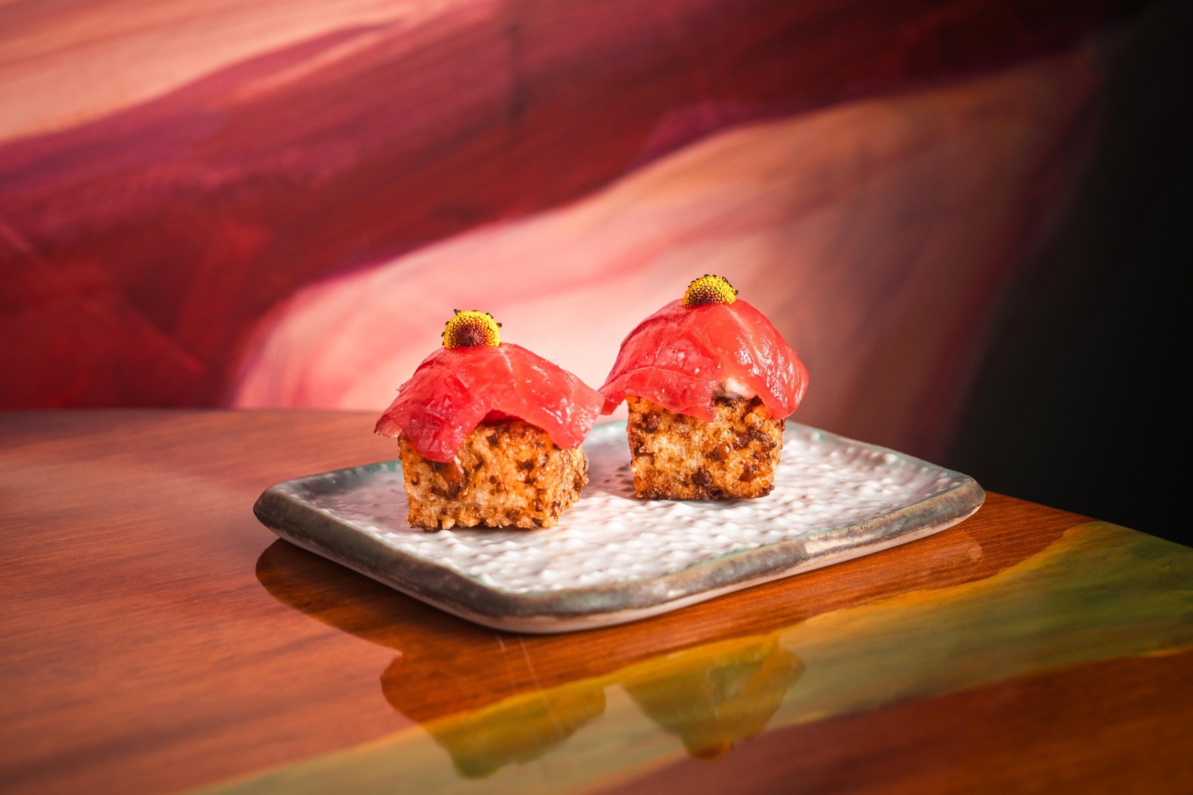 Two thick tapioca biscuits with slices of tuna on top of them.