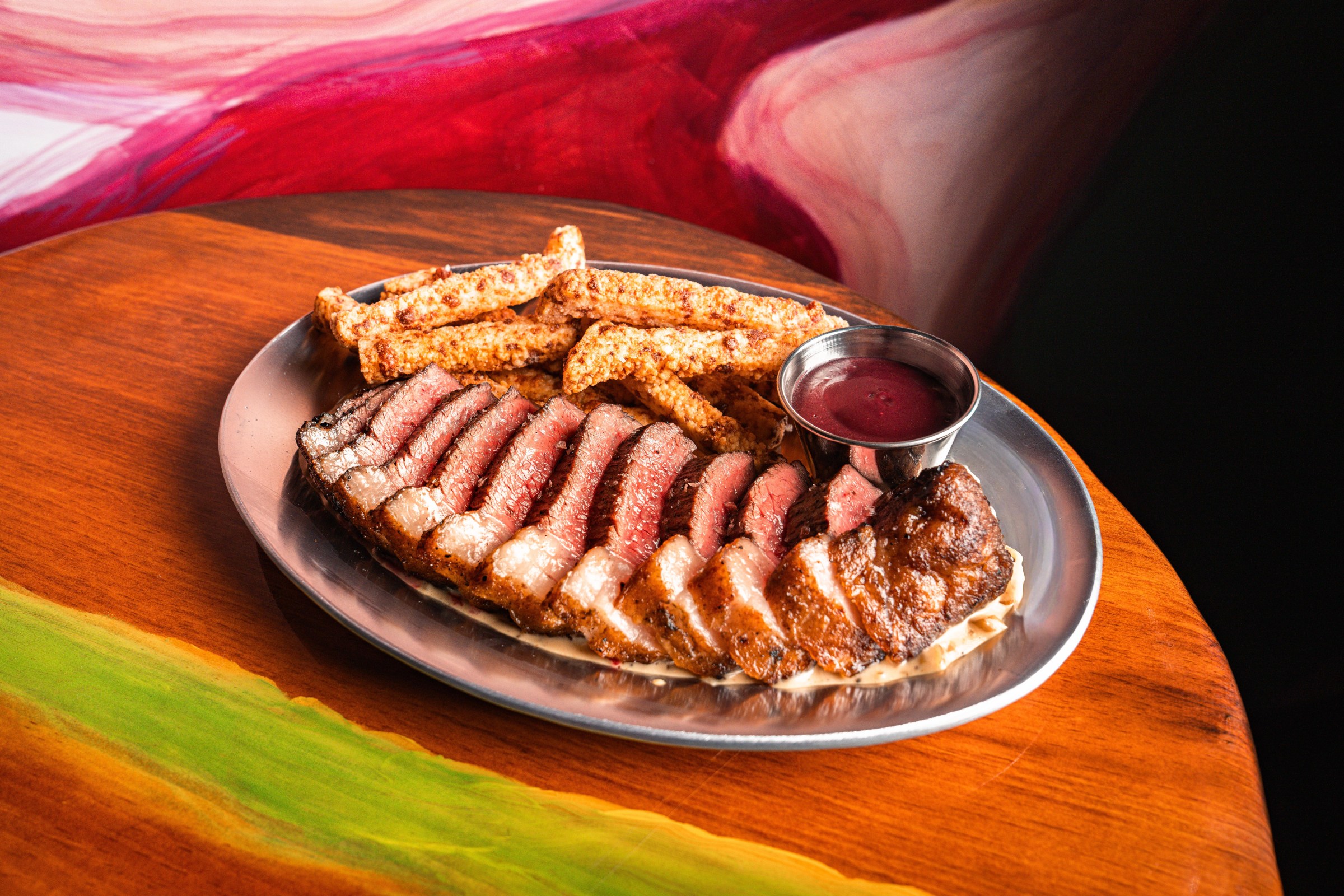 A plate of slices steak and fries.