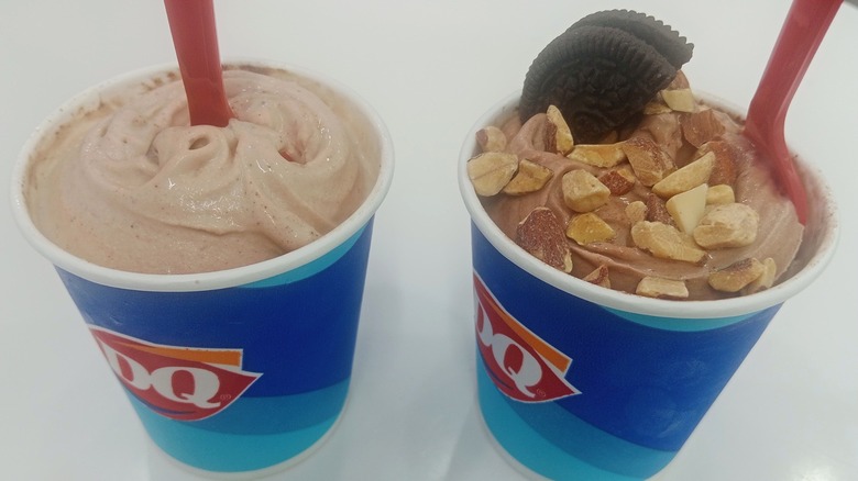 Two Dairy Queen Blizzards: one chocolate and the other with nuts and half a cookie
