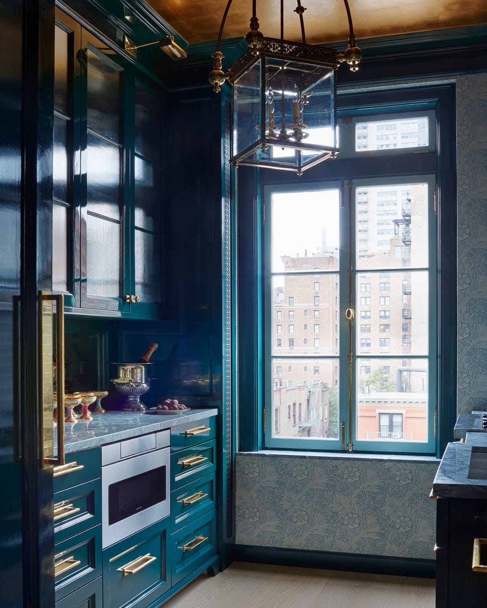Marshall Watson New York Apartment Kitchen small kitchen with dark blue cabinetry and brass pulls