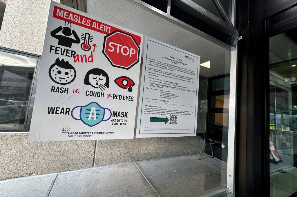 A measles alert sign hanging outside the entrance to the Cohen Children's Medical Center.