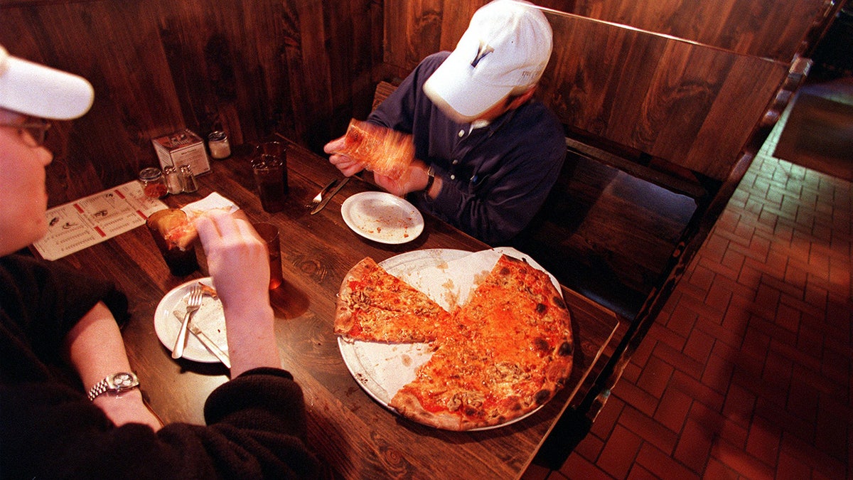 NEW HAVEN, CT - OCTOBER 18: Jonas Niaura, left, and Josh Siegel, right, eat a mushroom and cheese pizza at Modern Pizza. Both are graduate students at The Yale School of Management. (Photo by Jonathan Wiggs/The Boston Globe via Getty Images)