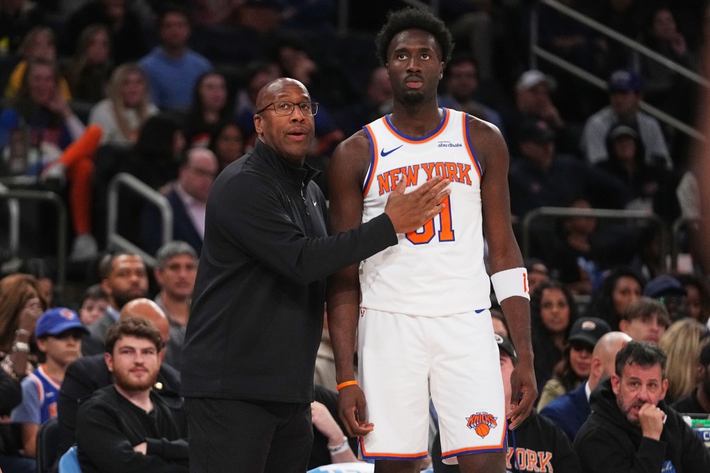 New York Knicks head coach Mike Brown talks to Mohamed Diawara during a basketball game.