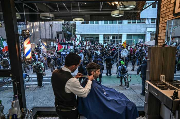 barber and client in a shop as protest occurs outside
