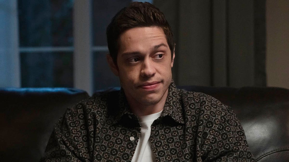 pete davidson sitting on a couch and looking to the side