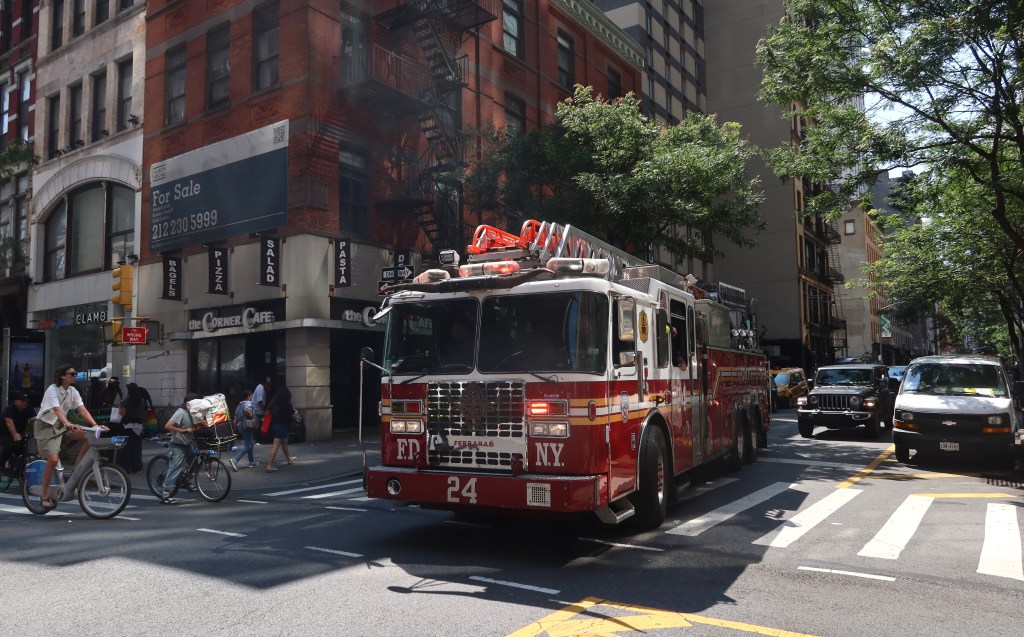 An FDNY Ladder Company 24 fire truck turns onto 6th Avenue in New York City.