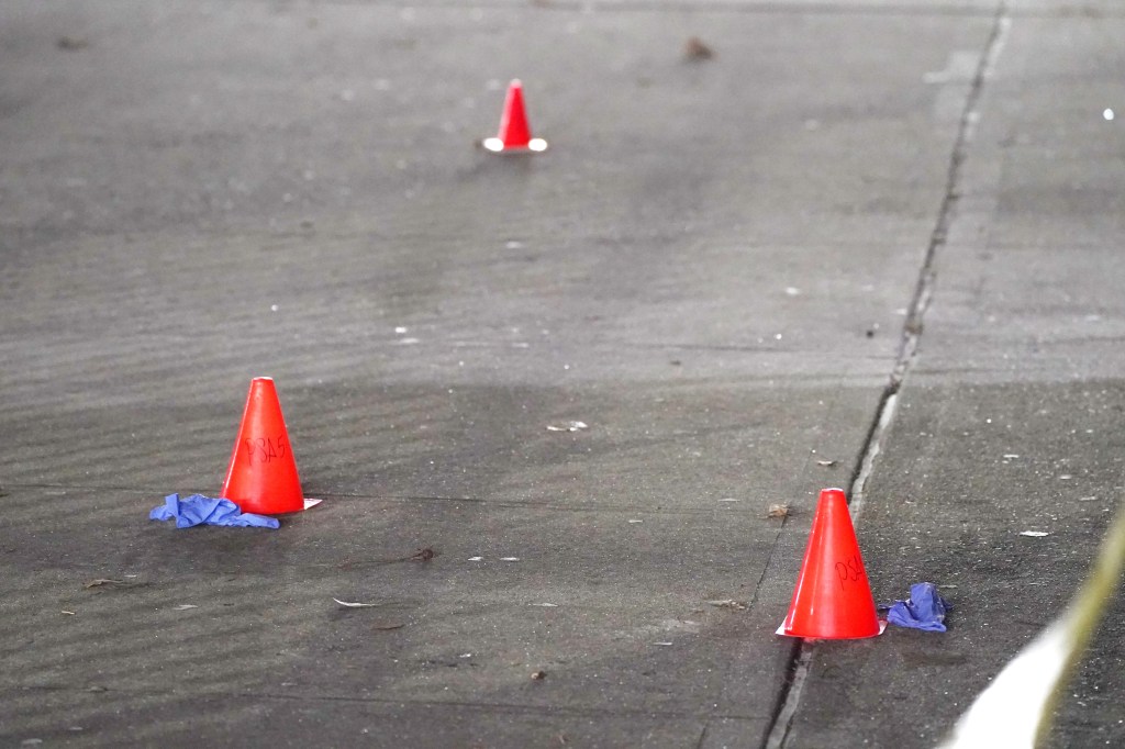 Red evidence cones marking the crime scene on the pavement.