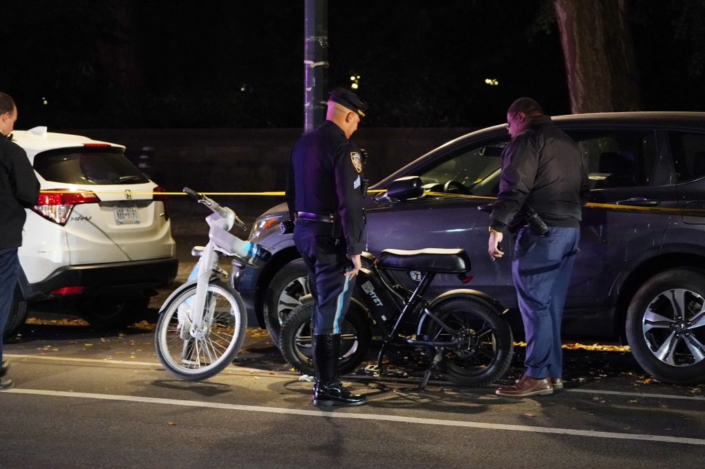 Police officers investigate the scene of a collision between two e-bikes.