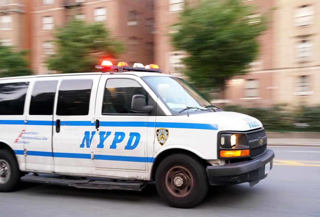 An NYPD van drives down a street in the Bronx.