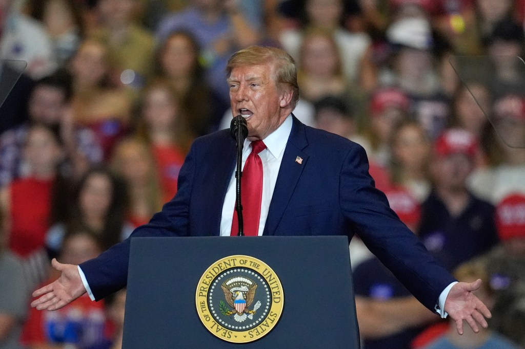President Donald Trump speaks at a campaign rally behind a lectern bearing the Presidential Seal.