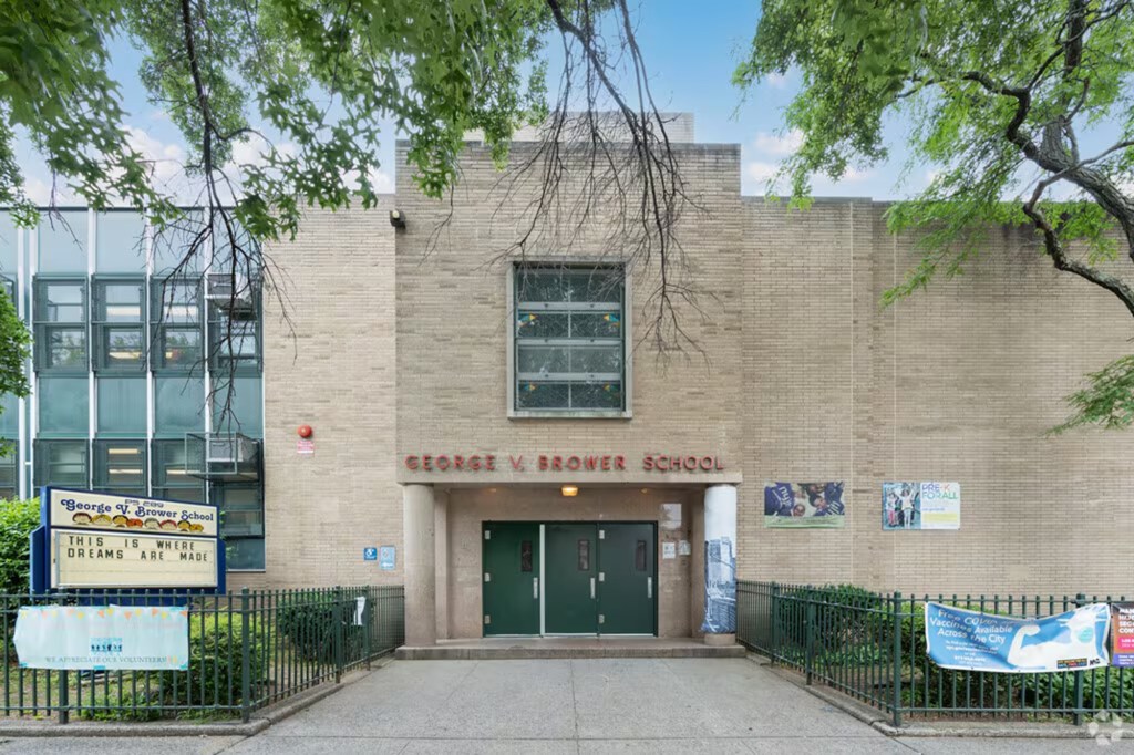 Exterior view of P.S. 289 The Brower School, featuring a brick facade, green double doors, and a sign reading "George V. Brower School."