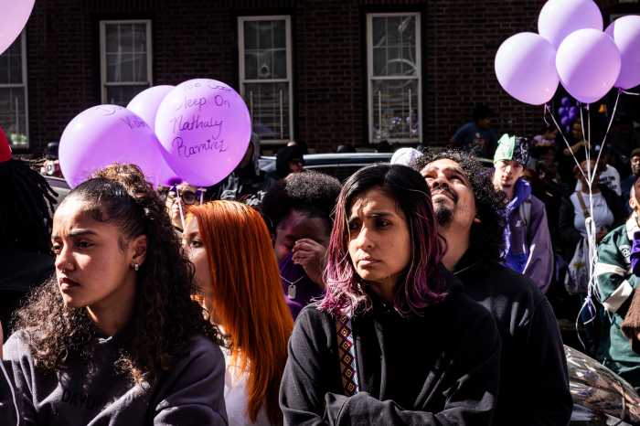 crowd holding purple balloons