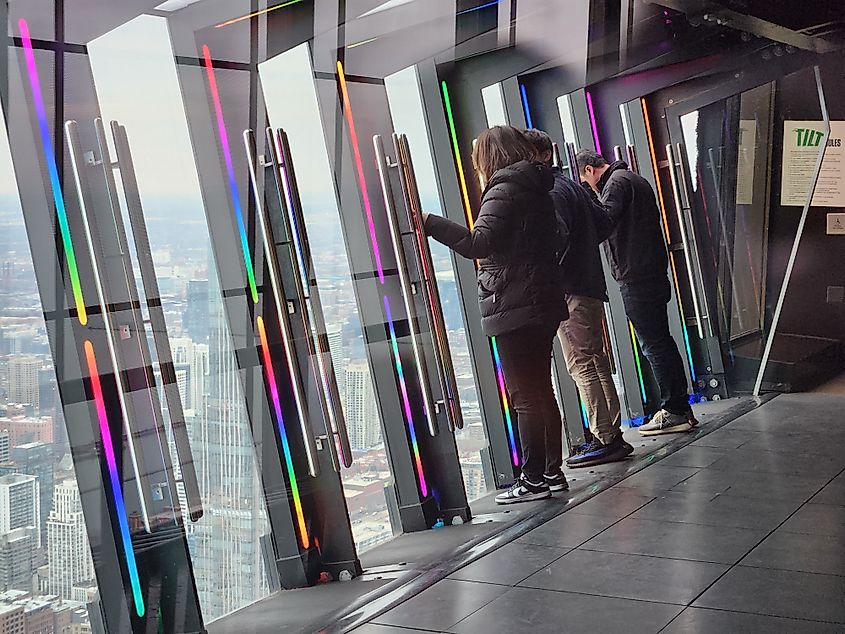 People on the Tilt attraction at the 360 Chicago Observation Deck in the John Hancock Center.
