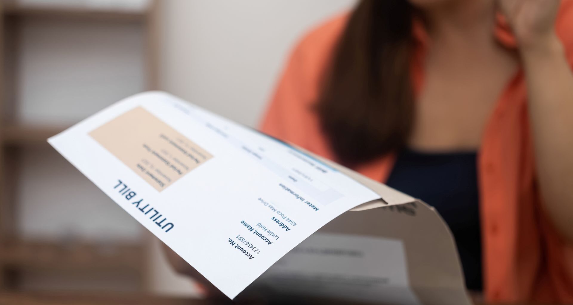 A woman looking at a utility bill.