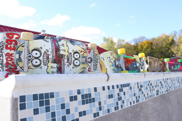 Spare skateboards line the top of a quarter pipe at...