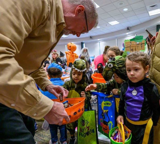 Lehigh County District Attorney Gavin P. Holihan gives candy to children from Love You More Early Learning Center on Friday, Oct. 31, 2025, during a Trick-or-Treat Candy Land themed adventure hosted by Lehigh County at Government Center in Allentown. (April Gamiz/The Morning Call)