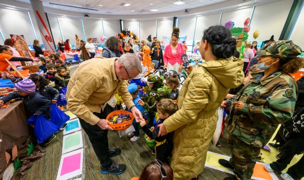 Lehigh County District Attorney Gavin P. Holihan gives candy to children from Love You More Early Learning Center on Friday, Oct. 31, 2025, during a Trick-or-Treat Candy Land themed adventure hosted by Lehigh County at Government Center in Allentown. (April Gamiz/The Morning Call)