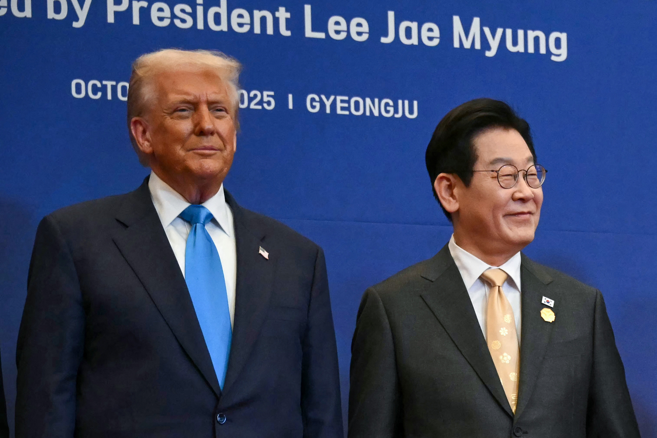 US President Donald Trump (left) and South Korea's President Lee Jae Myung take their position for a family photo with other leaders upon their arrival for a special dinner hosted in honor of US President Donald Trump and state leaders at the Hilton Gyeongju hotel in Gyeongju, North Gyeongsang Province, on Wednesday. (AFP-Yonhap)