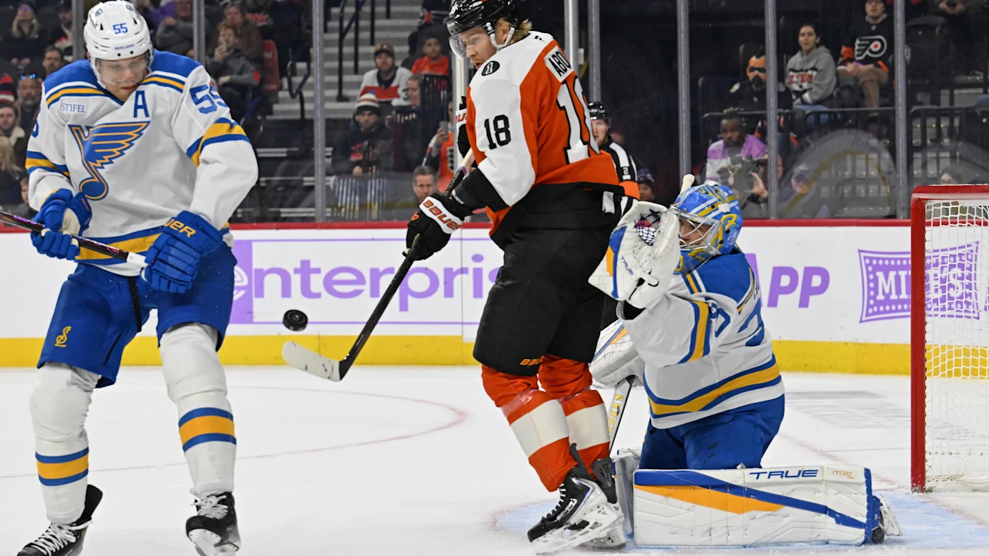 Nov 20, 2025; Philadelphia, Pennsylvania, USA; Philadelphia Flyers center Rodrigo Abols (18) tries to deflect the puck against St. Louis Blues defenseman Colton Parayko (55) and goaltender Joel Hofer (30) during the first period at Xfinity Mobile Arena. Mandatory Credit: Eric Hartline-Imagn Images