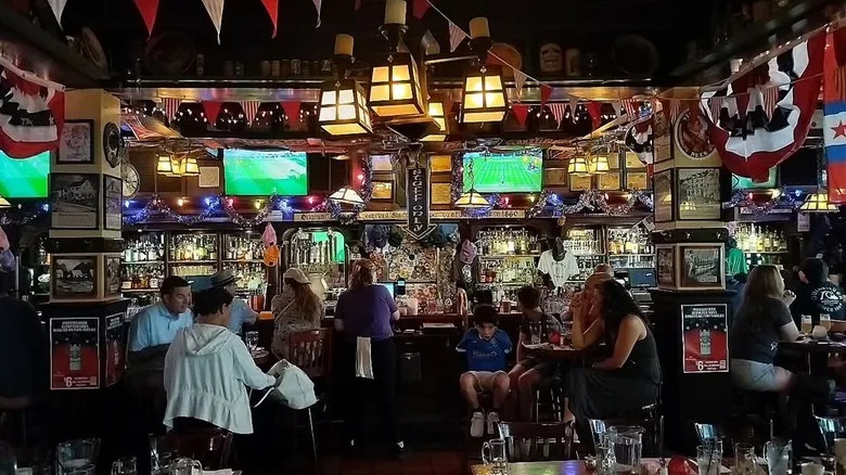 The bar inside McGillin's Olde Ale House with drinkers and TV screens