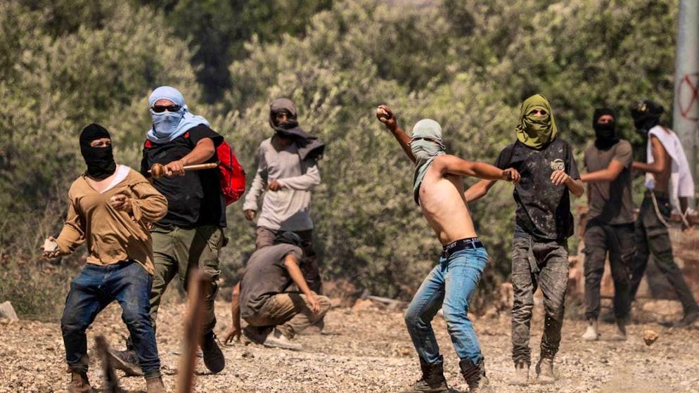 ARCHIVE - Right-wing Israeli settlers throw stones at Palestinian villagers during an attack on the West Bank village of Turmusaya. Photo: Ilia Yefimovich/dpa