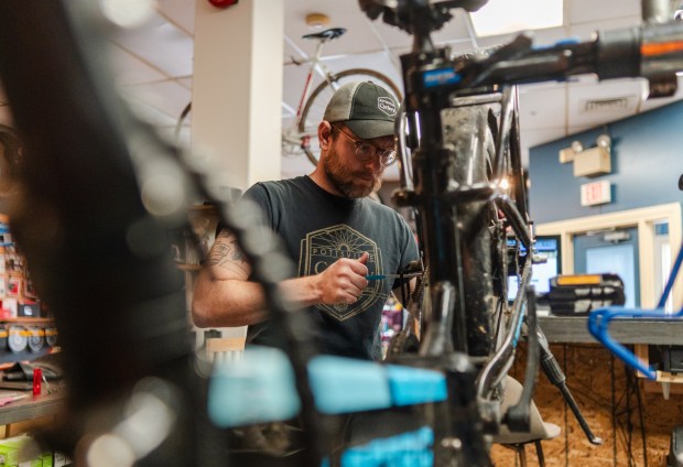 Pottsville Cyclery owner Allen Reinert inspects an e-bike at his shop, Thursday, Nov. 20, 2025, in Pottsville. (MATTHEW PERSCHALL/MULTIMEDIA EDITOR)