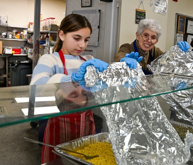 Volunteers Lauren Levin, 12, and Florence Kimmel help serve food Thursday, Nov. 27, 2025, during New Bethany's annual free Thanksgiving meal in Bethlehem. (April Gamiz/The Morning Call)