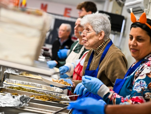 Volunteer Florence Kimmel, of Bethlehem smiles as she helps serve food Thursday, Nov. 27, 2025, during New Bethany's annual free Thanksgiving meal in Bethlehem. (April Gamiz/The Morning Call)