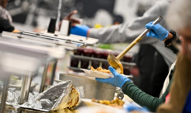Volunteers serve food on Thursday, Nov. 27, 2025, during New Bethany's annual free Thanksgiving meal in Bethlehem. (April Gamiz/The Morning Call)