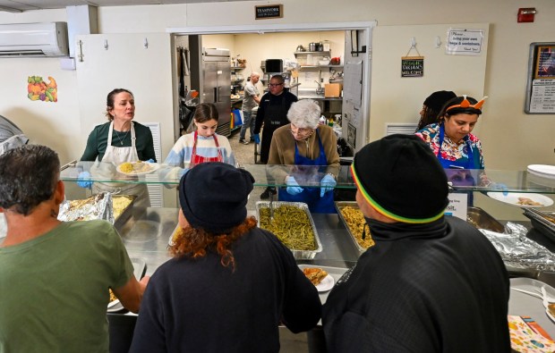 Volunteers serve food on Thursday, Nov. 27, 2025, during New Bethany's annual free Thanksgiving meal in Bethlehem. (April Gamiz/The Morning Call)